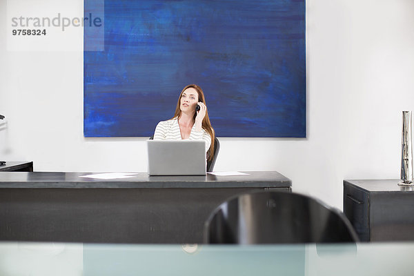 Geschäftsfrau im modernen Büro beim Telefonieren
