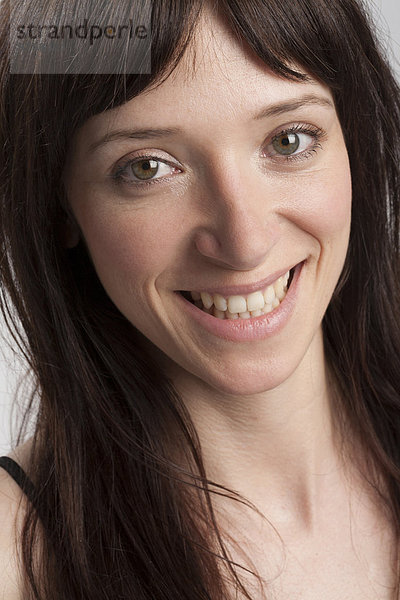 Porträt einer lächelnden Frau mit dunklem langem Haar
