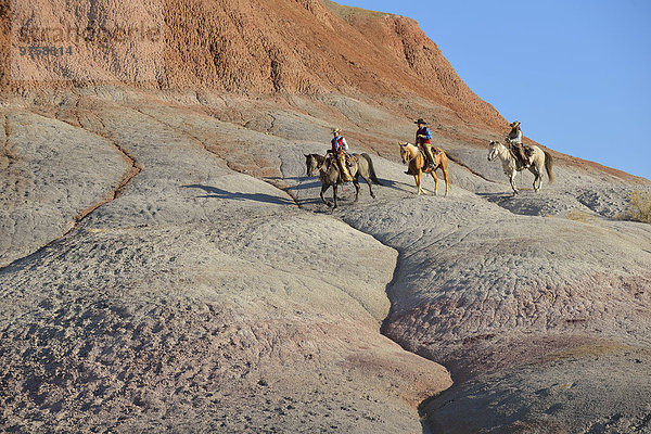USA  Wyoming  zwei Cowgirls und ein Cowboy beim Reiten in Badlands