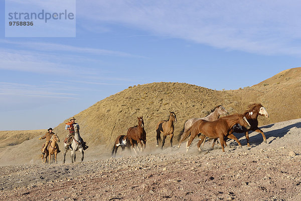 USA  Wyoming  zwei Cowboys hüten Pferde in Badlands