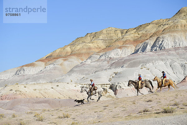 USA  Wyoming  zwei Cowboys und Cowgirl beim Reiten in Badlands