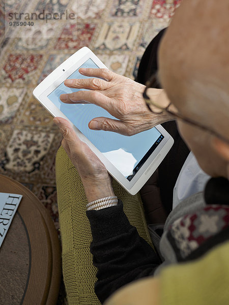 Alter Mann zu Hause mit digitalem Tablett
