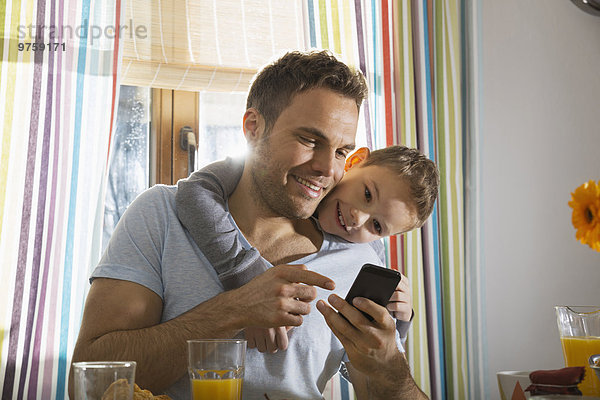 Vater und Sohn betrachten Smartphone