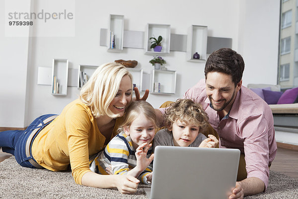 Glückliche Familie mit Laptop zu Hause