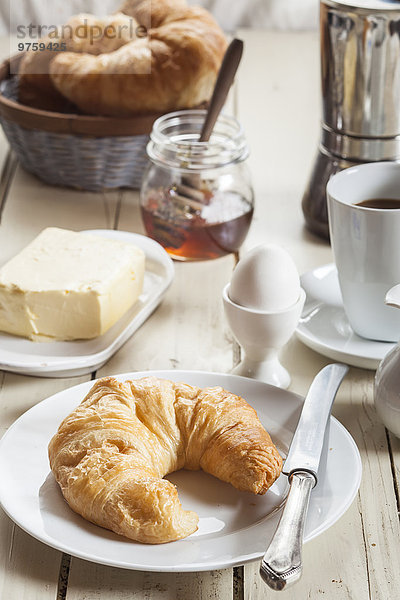 Frühstück mit Croissant  Ei  Kaffee  Honig und Butter