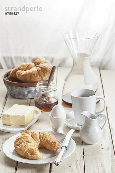 Frühstück mit Croissant  Ei  Kaffee  Honig und Butter
