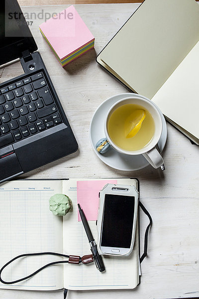 Kleines Heimbüro mit Handy  Laptop  Notebook  Kalender  Tee und Kekse