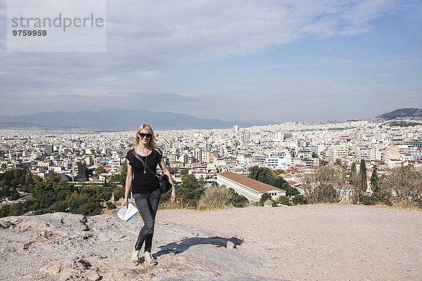 Griechenland  Athen  Blick auf die Stadt von der Akropolis mit weiblichen Touristen im Vordergrund