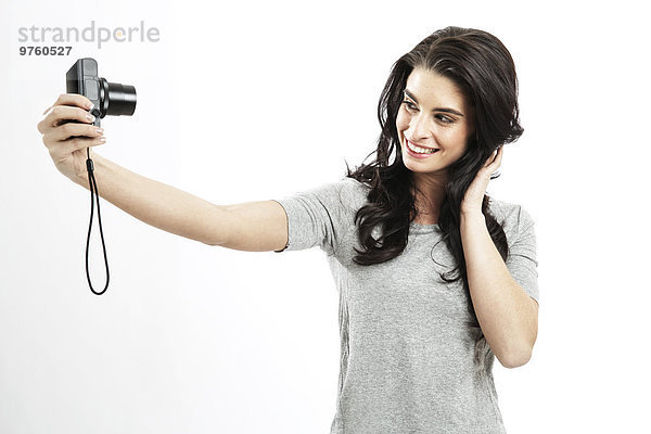 Porträt einer jungen Frau  die einen Selfie mit Kamera nimmt
