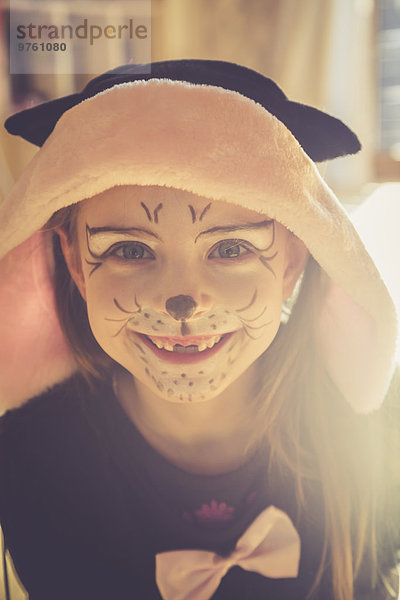Porträt eines lächelnden Mädchens mit Zahnlückenmaskerade als Katze