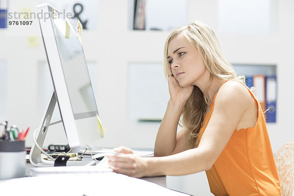 Kreative Bürofrau sitzt hinter ihrem Computer