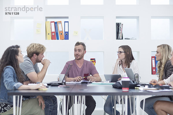 Kreative Büromenschen bei einer Besprechung am Besprechungstisch
