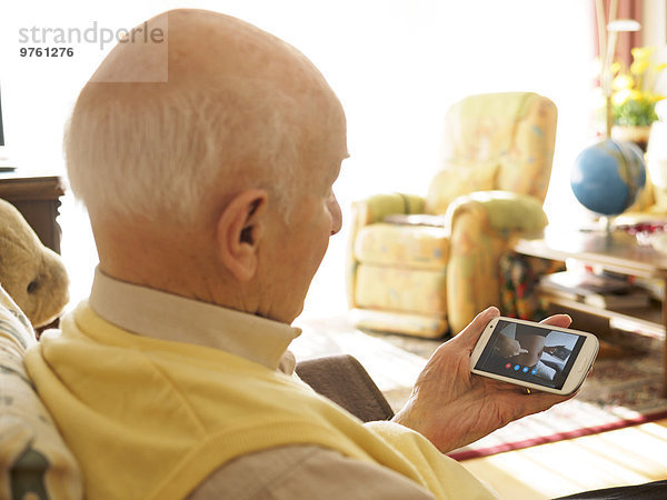 Großvater Videokonferenz mit schwangerer Enkelin via Smartphone