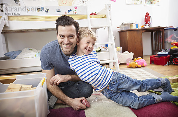 Vater und Sohn spielen zusammen im Kinderzimmer
