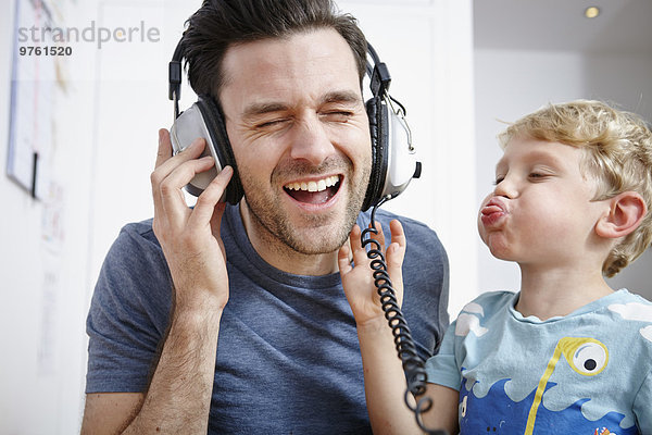 Vater und Sohn hören Musik über Kopfhörer