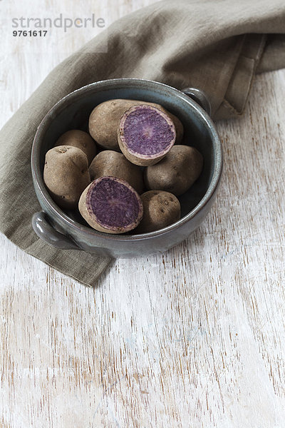 Kochtopf mit rohen Blaukongo-Kartoffeln