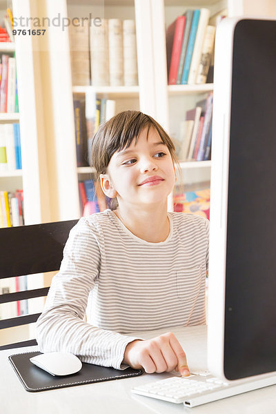 Porträt eines lächelnden Mädchens am Computer