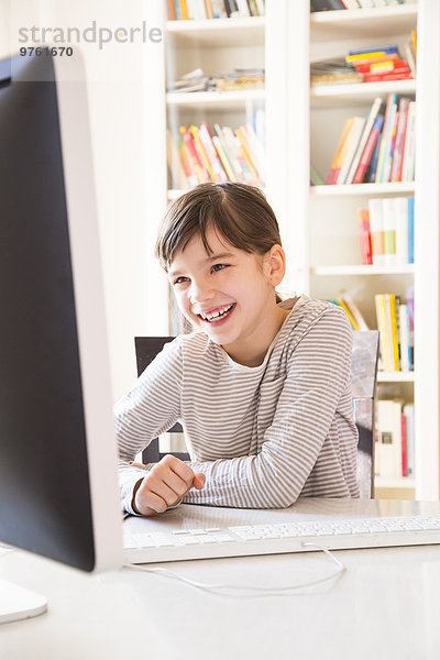 Porträt eines lächelnden Mädchens am Computer