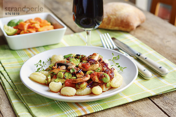 Fava-Bohnen und Champignons auf Gnocchi  serviert mit Salat  Rotwein und Brot