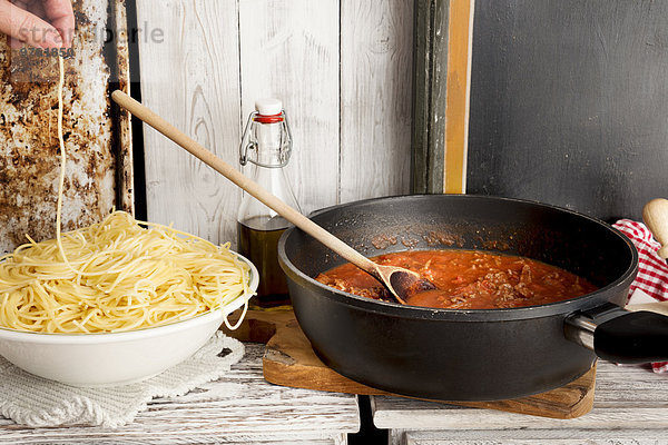 Spaghetti Bolognese  Spaghetti auf Teller und Sauce Bolognese in der Pfanne  Spaghetti knabbern