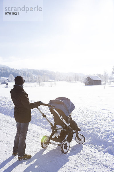 Österreich  Land Salzburg  Steinernes Meer  Mutter mit Kinderwagen im Winter