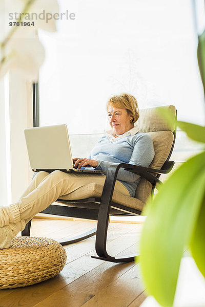 Seniorin zu Hause mit Laptop