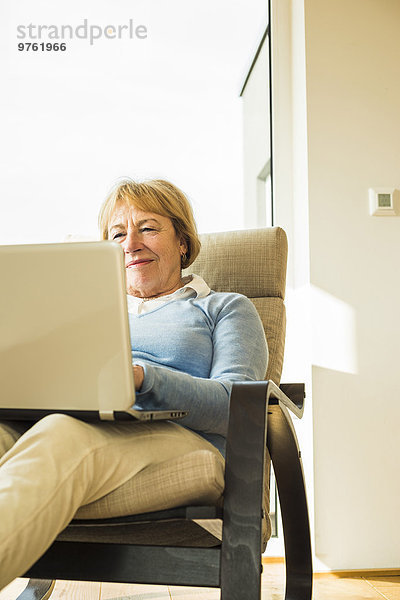 Seniorin zu Hause mit Laptop