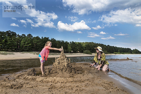 Estland  Peipussee  Kauksi Strand  Mädchen und Mutter bauen Sandburg