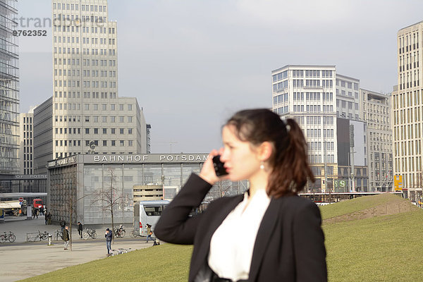 Deutschland  Berlin  Potsdamer Platz  Geschäftsfrau auf Smartphone