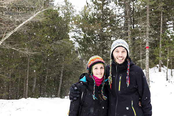 Lächelndes Paar im Wald im Winter