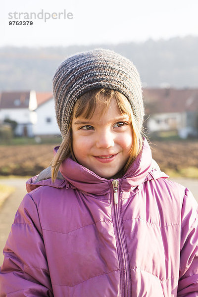 Porträt des kleinen Mädchens mit Wollmütze und rosa Winterjacke