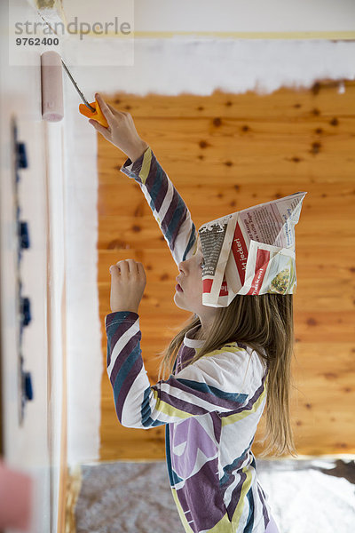 Mädchen malen Holzwand mit Farbroller