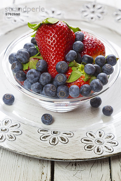 Frische Erdbeeren und Heidelbeeren in Schale auf Teller