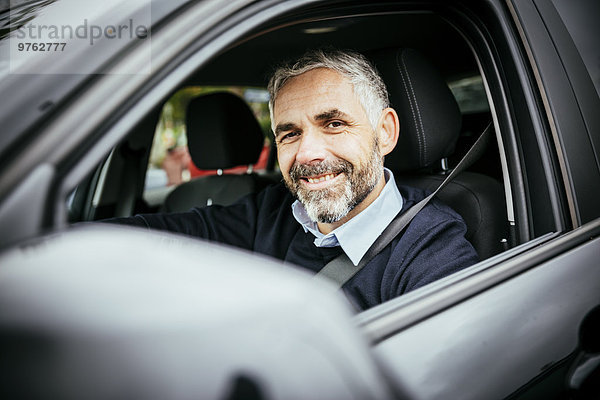 Lächelnder Mann beim Autofahren