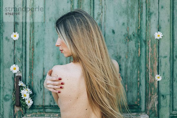 Nackter Rücken einer blonden jungen Frau im Freien