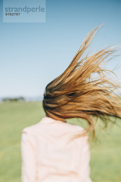 Wind bewegt lange Haare einer Frau