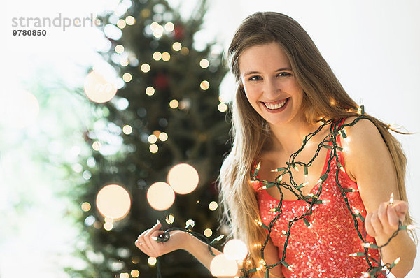 junge Frau junge Frauen Portrait Beleuchtung Licht Weihnachten Weihnachtsbaum Tannenbaum schmücken