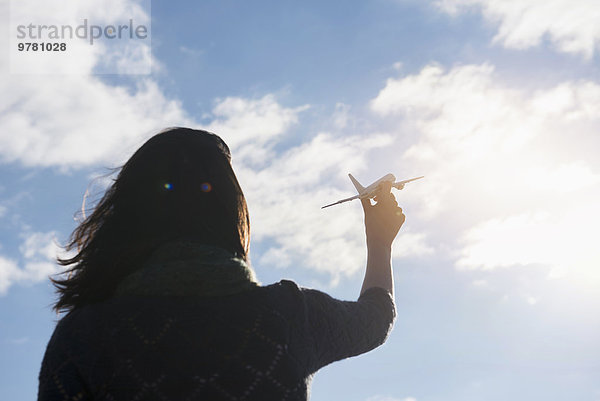 Flugzeug junge Frau junge Frauen Himmel Modell halten Rückansicht Ansicht