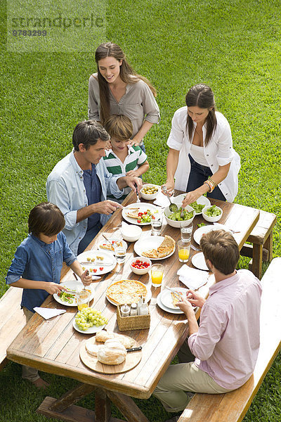Familie und Freunde genießen gesundes Essen im Freien