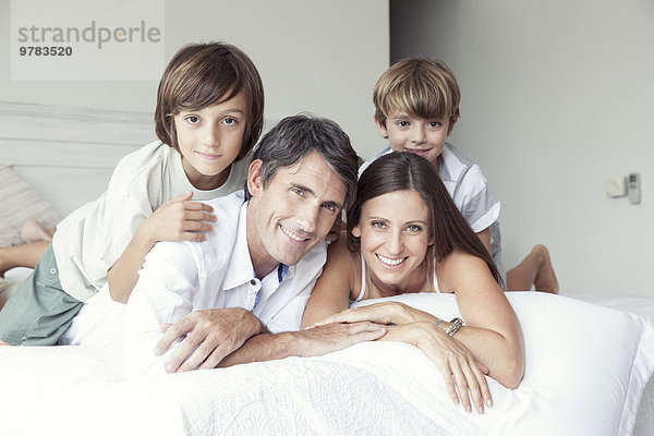 Familie auf dem Bett liegend  Portrait