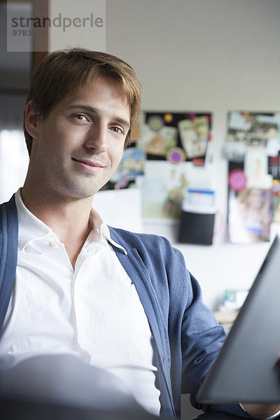 Mann mit digitalem Tablett im Büro