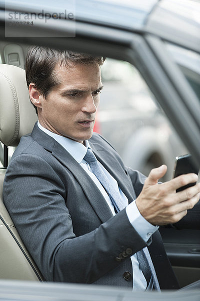 Mann liest SMS während der Fahrt