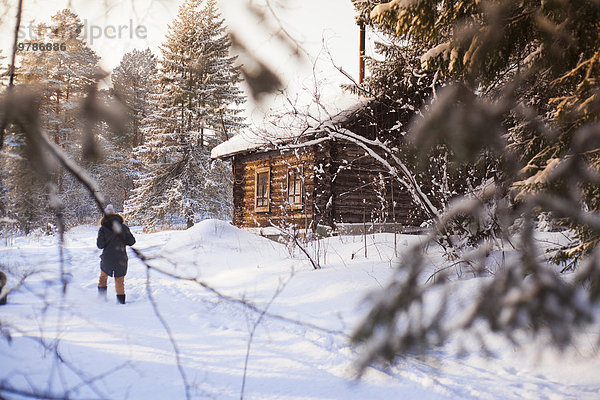 nahe Blockhaus Europäer Frau gehen Schnee Wald