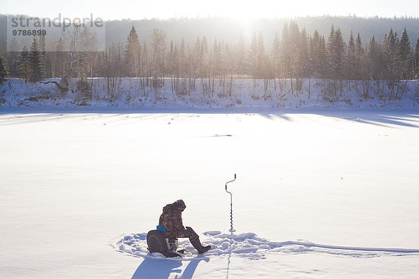Mann Schnee Eis Feld angeln