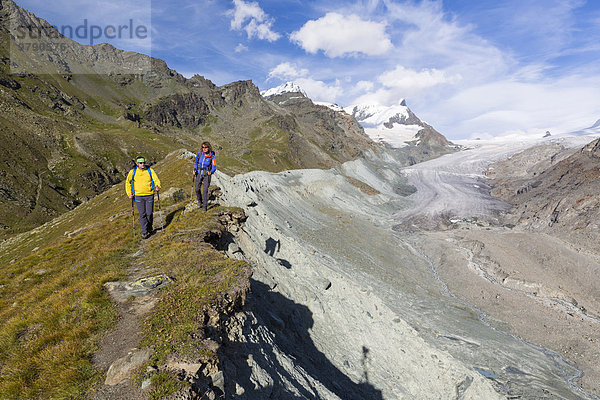 Ein Mann und eine Frau beim Wandern auf der Moräne des Findelgletschers an der Fluhalp  Zermatt  Wallis  Schweiz  Europa