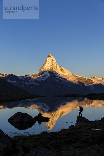 Erstes Sonnenlicht am Matterhorn  Spiegelung im Stellisee mit Person  Zermatt  Wallis  Schweiz  Europa