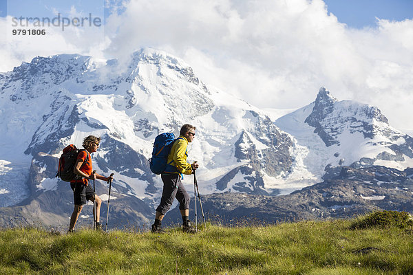 'Ein Mann und eine Frau beim Wandern  Plateau ''Schweifinen''  dahinter Breithorn und Klein Matterhorn  Zermatt  Wallis  Schweiz  Europa'