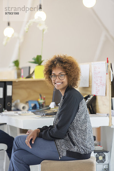 Porträt einer Frau im Büro sitzend und lächelnd