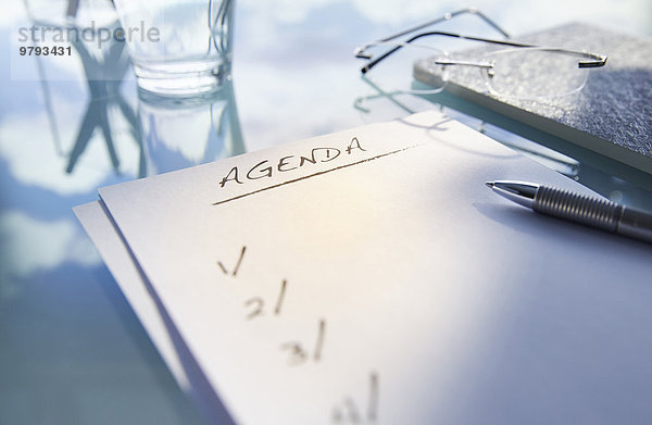 Nahaufnahme von Schreibtisch mit  Glas  Gläser und Notiz sagen Agenda   Stift