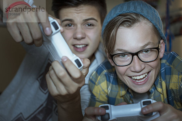 Zwei Teenager Jungen spielen zusammen Videospiel